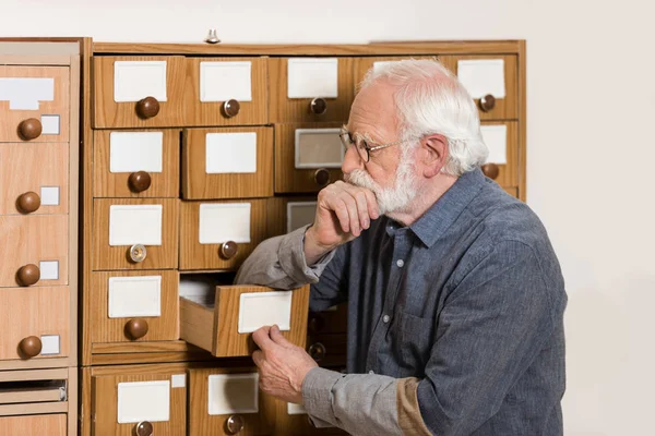 Düşünceli Kıdemli Erkek Arşivci Katalog Kutulara Yaslanmış — Stok fotoğraf
