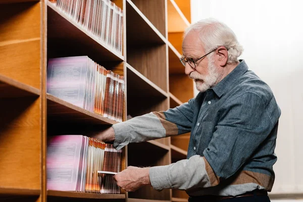 Zijaanzicht Van Grijze Haren Bibliothecaris Boek Zoekt — Stockfoto