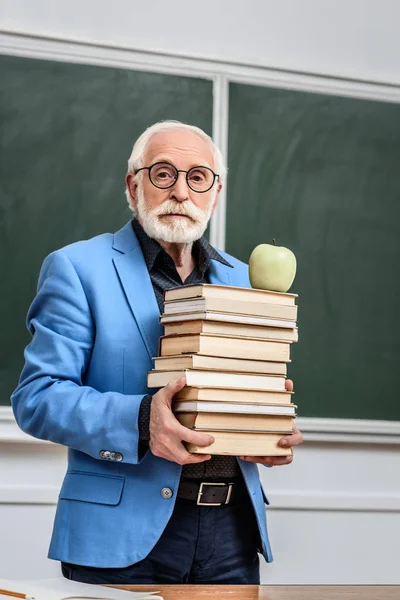 Professor Cabelo Cinza Segurando Pilha Livros Com Maçã Topo — Fotografia de Stock