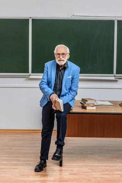 Professore Capelli Grigi Seduto Sul Tavolo Aula Con Libro Mano — Foto Stock