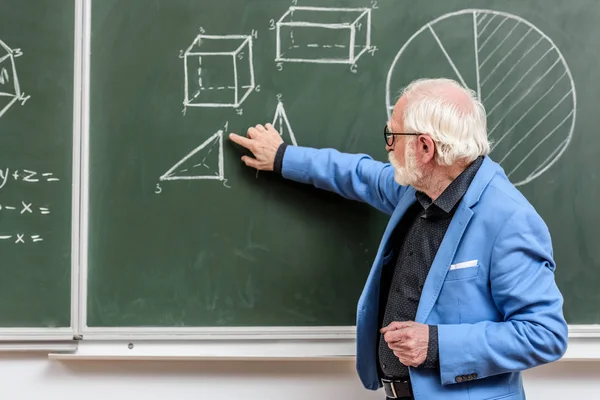 Professor Cabelo Cinza Apontando Algo Com Dedo Quadro Negro — Fotografia de Stock