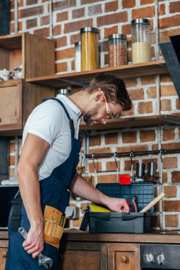 Mutfakta çalışan toolbox ile genç tamirci