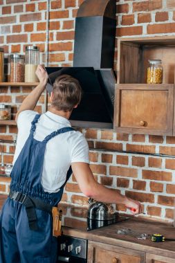 arkadan görünüşü genç tamirciyle mutfakta extractor hood sabitleme