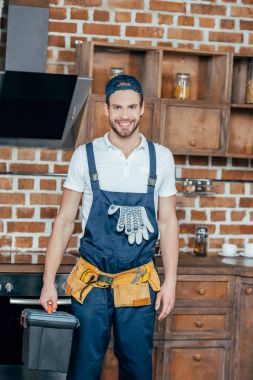 professional home master with toolbox and tool belt smiling at camera  clipart