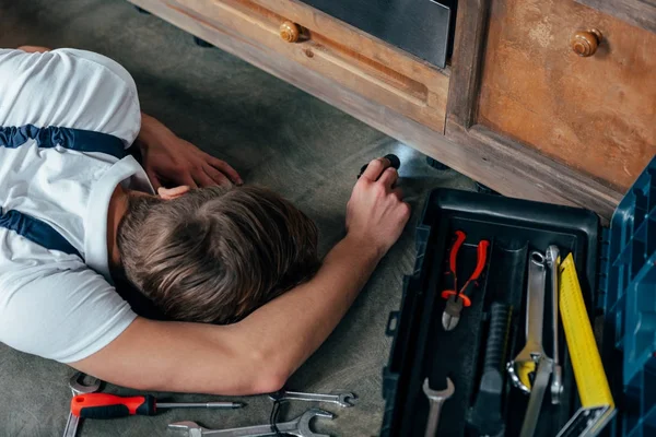 Hochwinkelaufnahme Eines Jungen Reparateurs Der Den Ofen Mit Taschenlampe Überprüft — Stockfoto