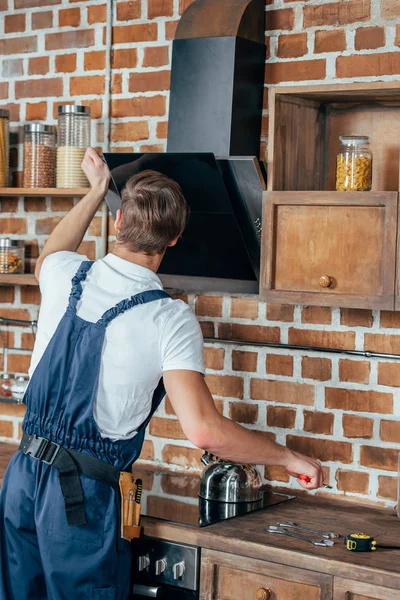 Vista Posteriore Del Giovane Tuttofare Fissaggio Cappa Aspirante Cucina — Foto Stock