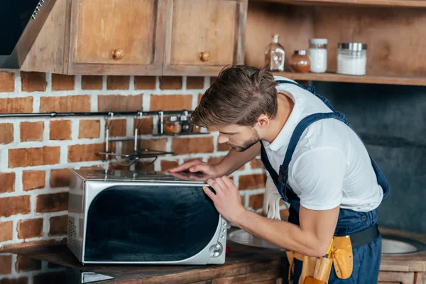 Profissional Jovem Faz Tudo Reparar Forno Microondas Cozinha — Fotografia de Stock