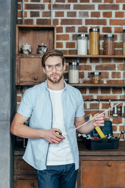 gözlük yakışıklı genç adam teyp ölçme ve kameraya bakarak holding