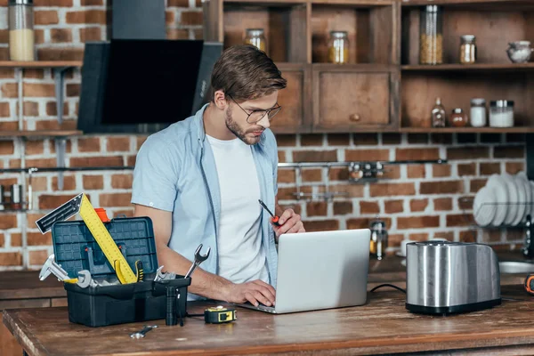 Young Man Eyeglasses Using Laptop While Repairing Toaster Home — Stock Photo, Image