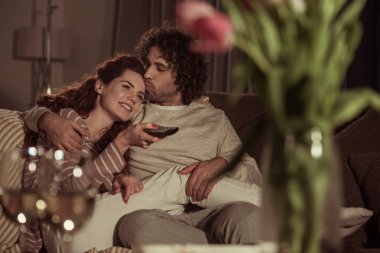 mutlu çift kanepede akşam TV izlerken  