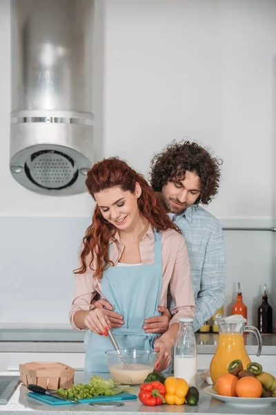 Boyfriend Hugging Girlfriend While She Preparing Batter — Free Stock Photo