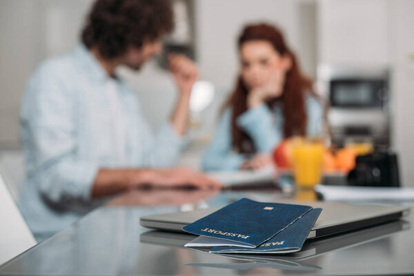 couple planning trip with passports on foreground