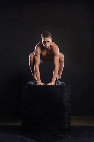 黒のブロックからジャンプ運動の上半身裸若いスポーツマン — ストック写真