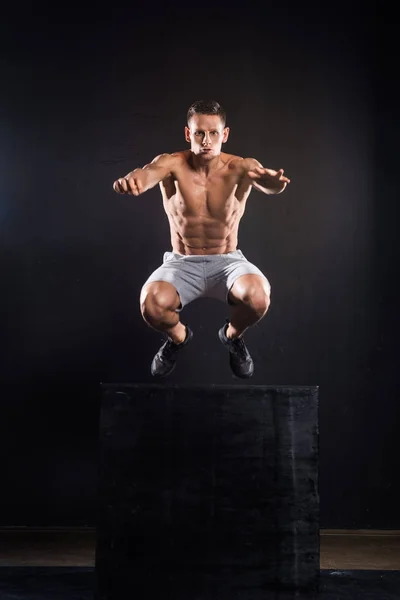 Athletischer Junger Sportler Springt Von Block Auf Schwarz — Stockfoto