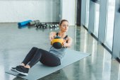 fokussierte Sportlerin macht Übungen mit Ball im Fitnessstudio