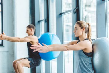 genç adam ve kadın fitness topları spor salonunda egzersiz