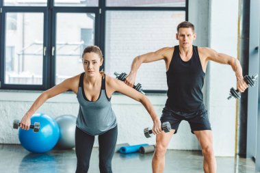 spor salonunda dumbbells ile spor eğitimi Çift odaklı