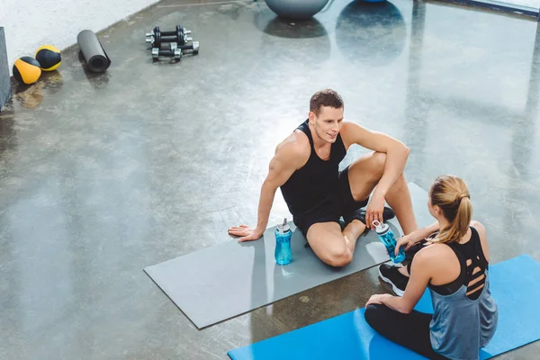 Vista Ángulo Alto Deportista Deportista Con Botellas Agua Sentados Colchonetas —  Fotos de Stock