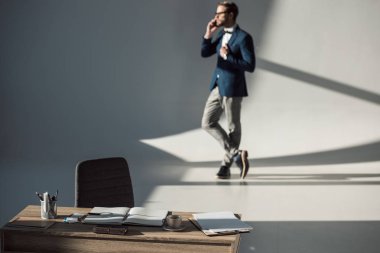 office ile tablo seçici odak sağlar ve açık defter ve telefonla konuşan işadamı