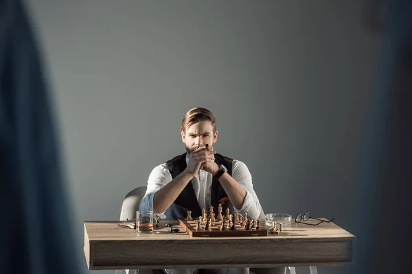 葉巻チェスを再生しながらカメラ目線でスタイリッシュなビジネスマンの選択と集中 — ストック写真