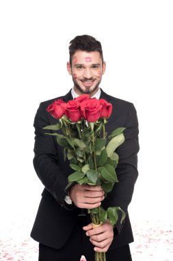 man with lips traces on face showing bouquet of roses isolated on white, valentines day concept