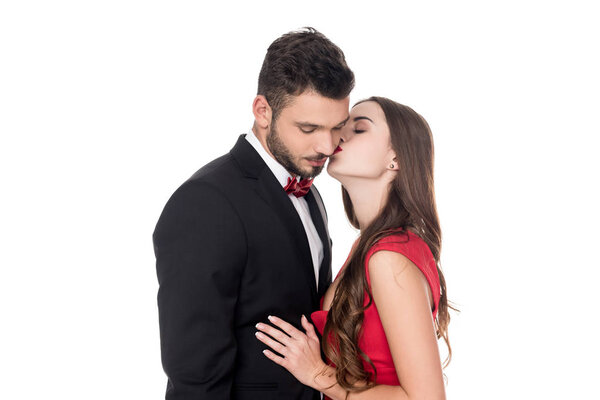 side view of girlfriend kissing boyfriends cheek isolated on white