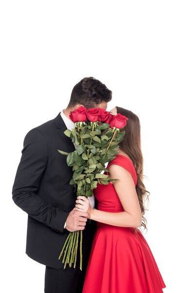 heterosexual couple kissing and covering faces with bouquet isolated on white