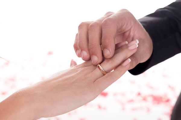 cropped image of boyfriend wearing ring on girlfriends finger isolated on white, valentines day concept