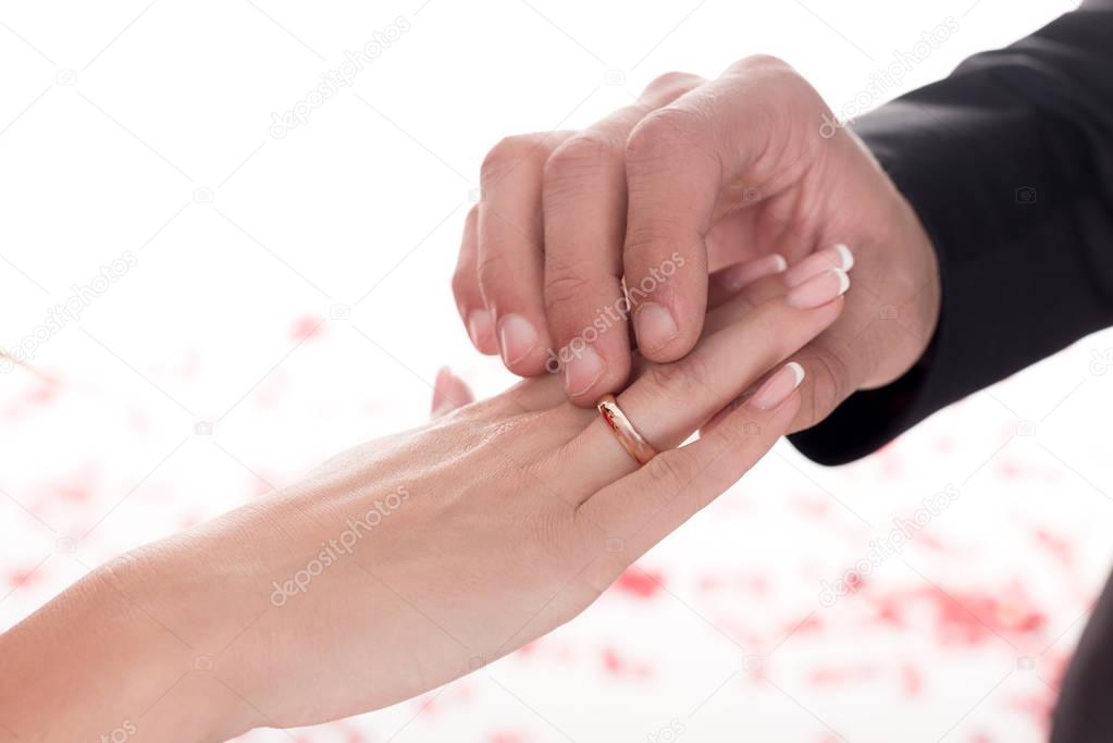 cropped image of boyfriend wearing ring on girlfriends finger isolated on white, valentines day concept