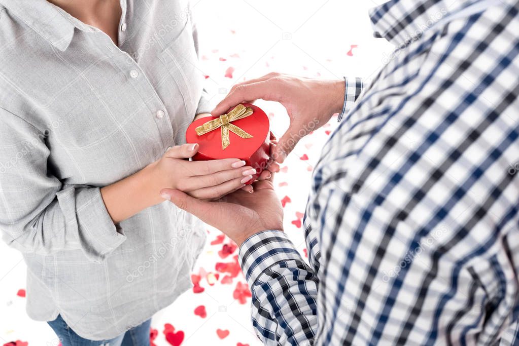 cropped image of girlfriend giving boyfriend present box isolated on white, valentines day concept