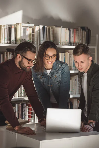 Amici Multiculturali Sorridenti Guardando Laptop Biblioteca — Foto Stock