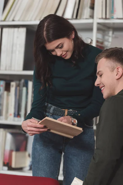 Fille Montrant Quelque Chose Dans Livre Ami Dans Bibliothèque — Photo gratuite