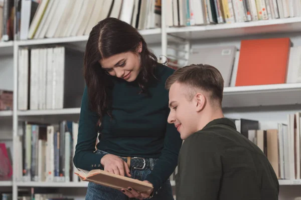 Menina Mostrando Algo Livro Para Amigo Biblioteca — Fotografia de Stock