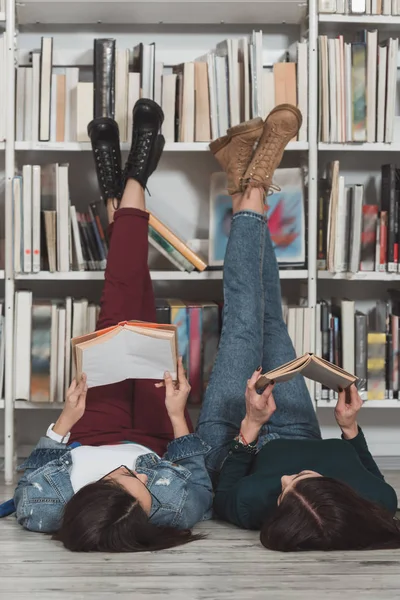 Amigos Multiculturais Deitado Chão Biblioteca Com Pernas Para Cima Ler — Fotografia de Stock