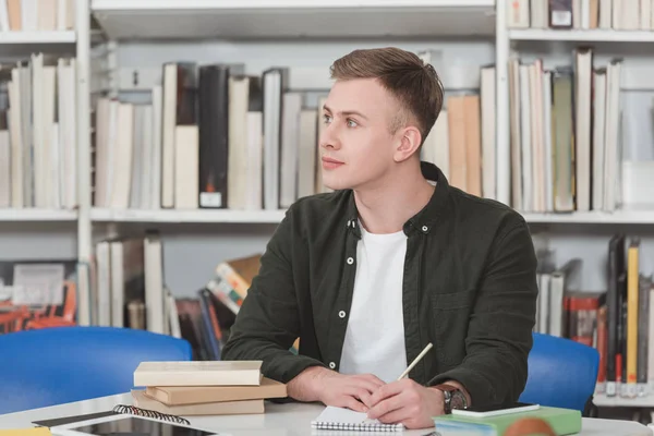 Male Student Writing Something Notebook Looking Away Library — Stock Photo, Image