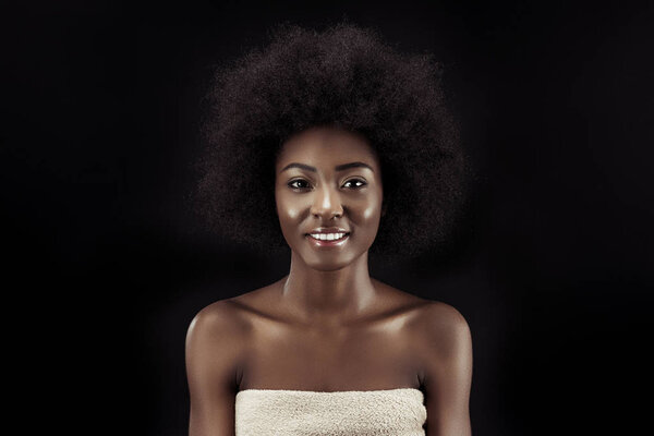attractive african american woman looking at camera isolated on black