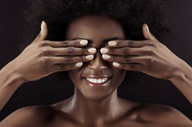 güzel bir Afrikalı-Amerikalı kadın siyah izole elleriyle gözlerini kapsayan