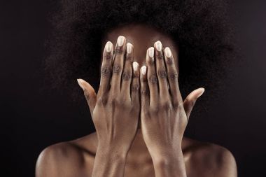 Afrikalı-Amerikalı kadın siyah izole elleriyle yüzünü kapsayan