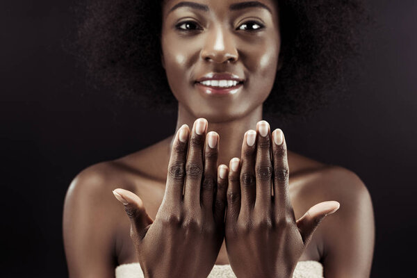 красивая африканская американская женщина показывает свои ногти изолированы на черном
