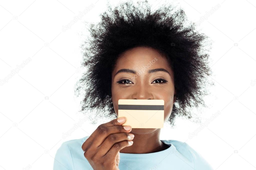 young woman holding gold credit card in front of face isolated on white