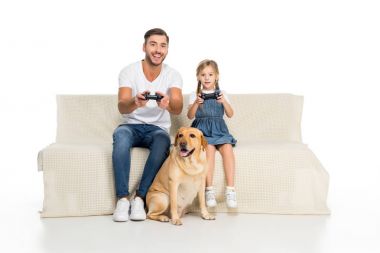 Baba ve oyun sırasında yakın oturan köpek çubukları ile bilgisayar oyunu oynamak, üzerinde beyaz izole kız