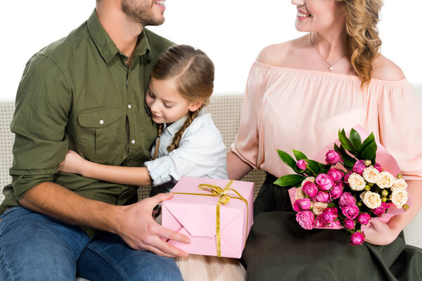 partial view of happy family with presents on sofa isolated on white