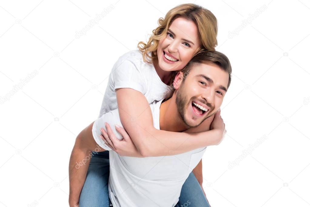 excited man piggybacking his smiling girlfriend, isolated on white