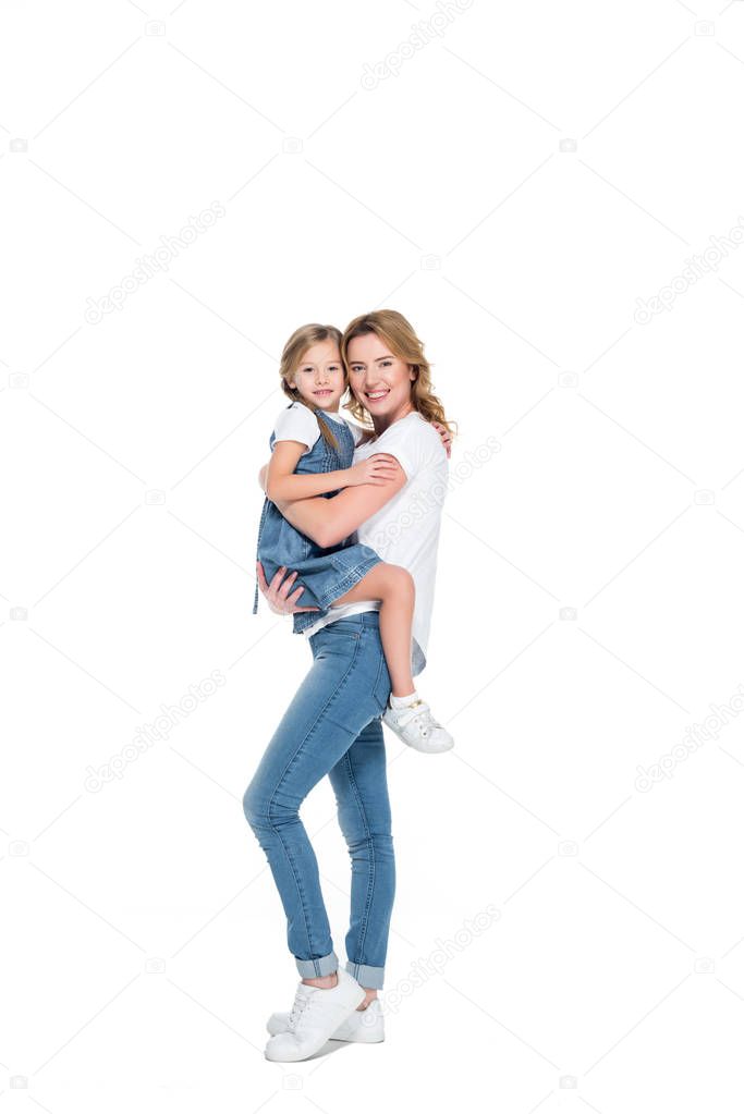 smiling mother holding happy daughter on hands, isolated on white