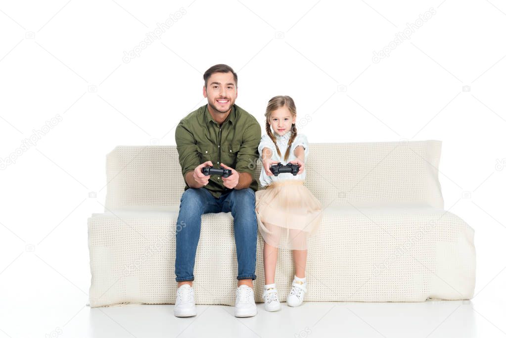 smiling father and daughter playing video game together isolated on white