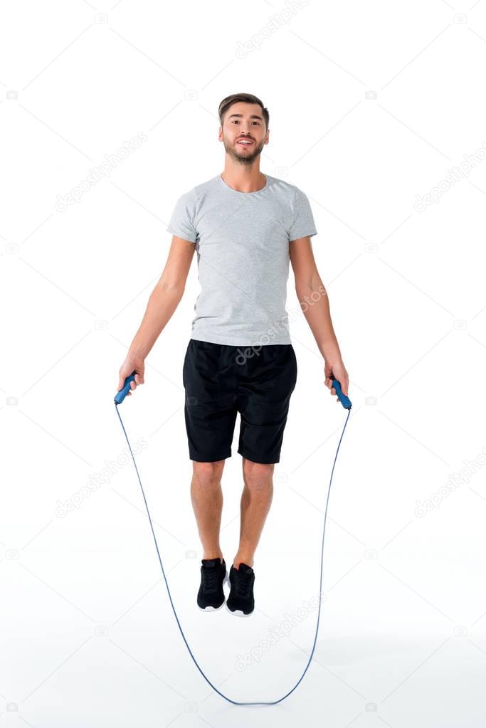 attractive sportsman with jumping rope exercising isolated on white