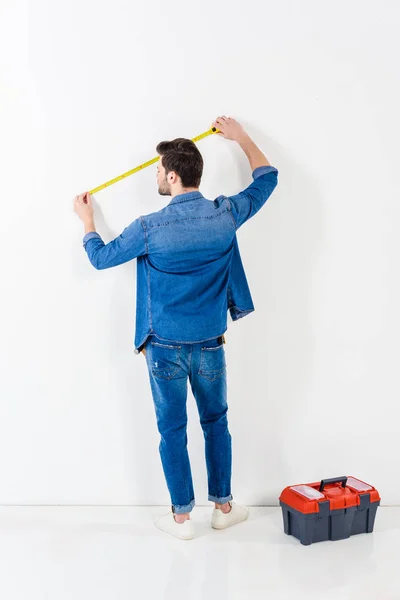 Rear View Man Measuring Wall Tape Measure White — Stock Photo, Image