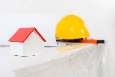 Sarı kask ve tablo üzerinde küçük ev