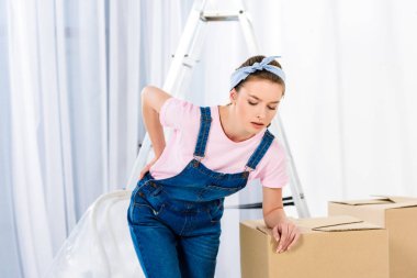 girl with pain in back after moving heavy boxes