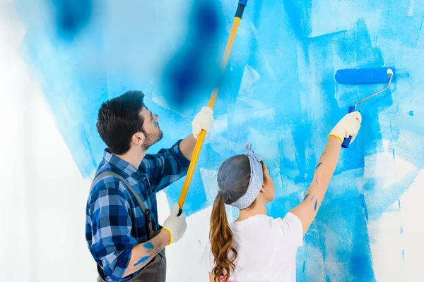 彼氏とガール フレンド絵画壁に青ペンキ — ストック写真
